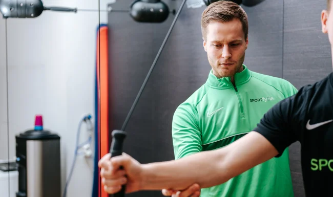 SportFysiotherapie Houten, de sportfysiotherapeut helpt bij het zoeken van de juiste positie van de arm.